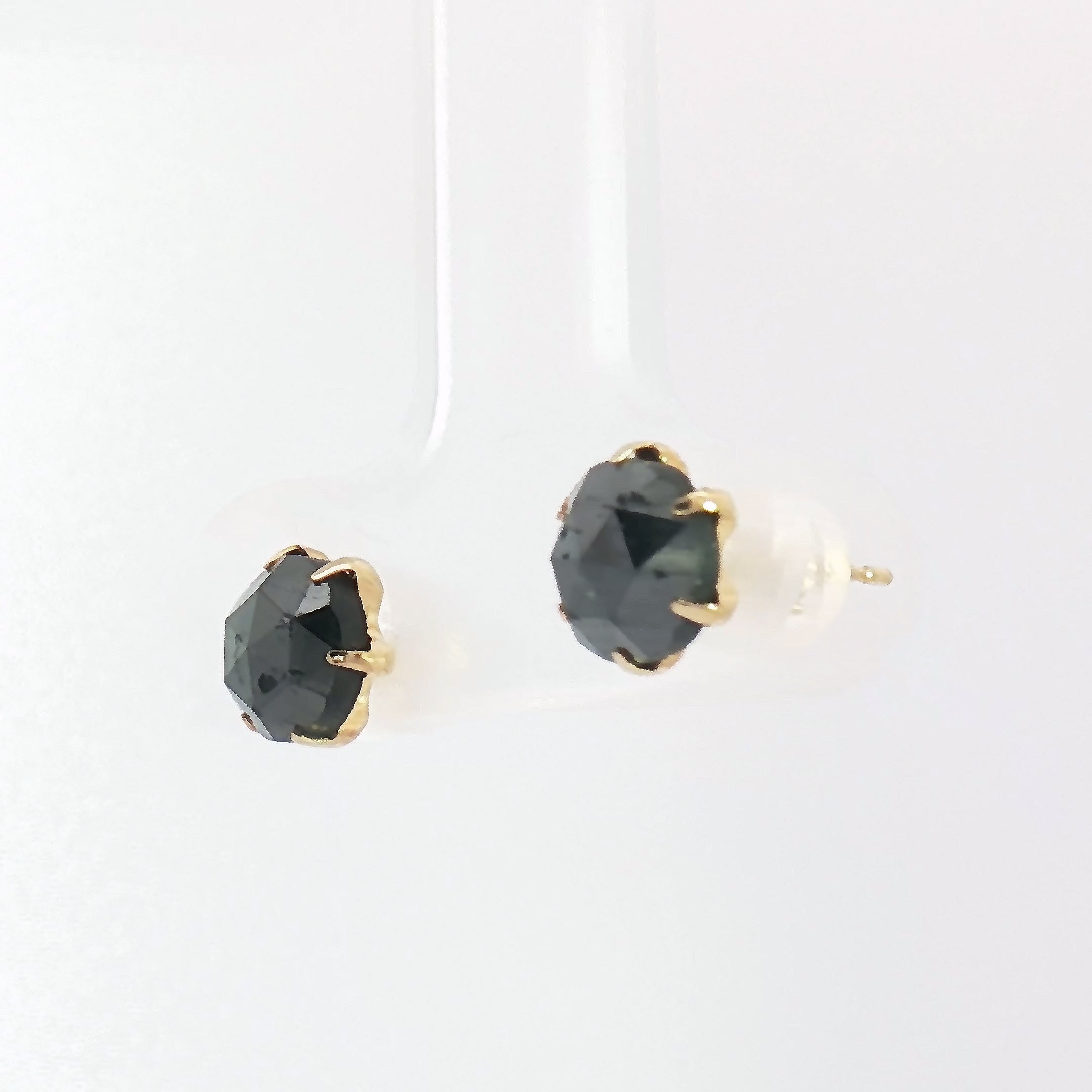 Close-up of 2.40ct fancy black diamond stud earrings in yellow gold