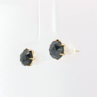 Close-up of 2.40ct fancy black diamond stud earrings in yellow gold